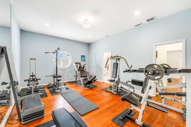 exercise area with recessed lighting, wood finished floors, visible vents, and baseboards