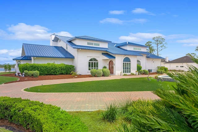 view of front of property with a standing seam roof, a front lawn, and metal roof