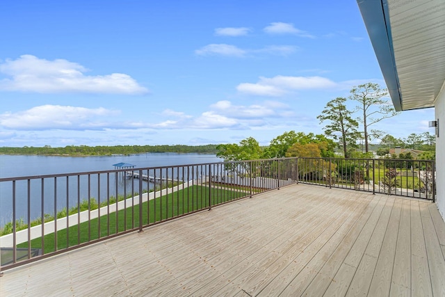 wooden terrace with a water view, a boat dock, and a lawn