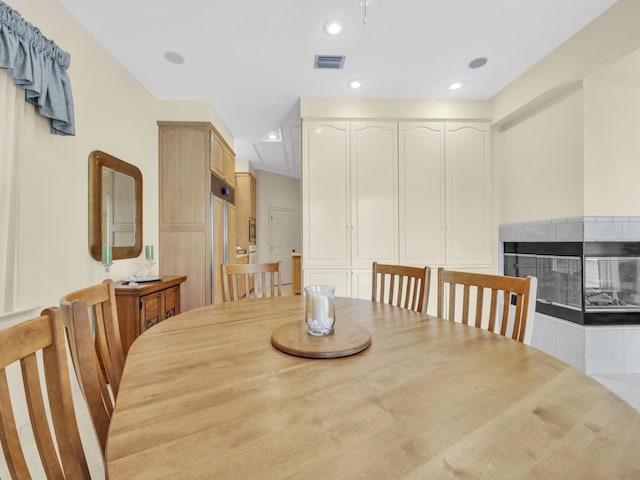 dining area featuring visible vents, a tiled fireplace, and recessed lighting