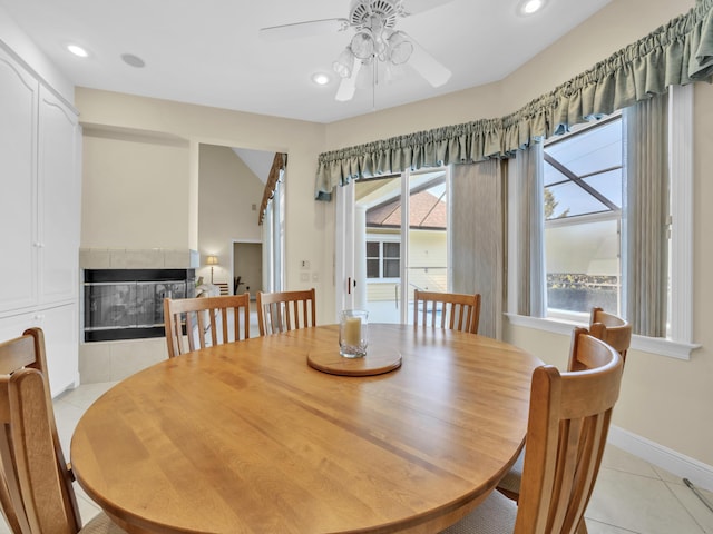 dining space with recessed lighting, a tiled fireplace, light tile patterned flooring, ceiling fan, and baseboards