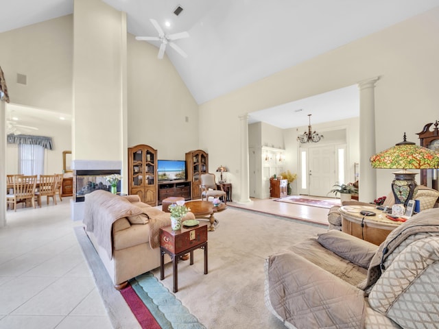 living room with light tile patterned floors, decorative columns, high vaulted ceiling, and ceiling fan with notable chandelier