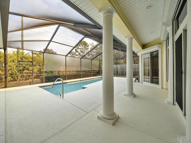 pool with glass enclosure, a patio, and fence