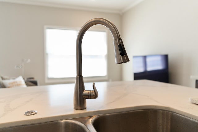 interior details with light stone countertops and a sink