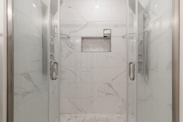 bathroom with a marble finish shower