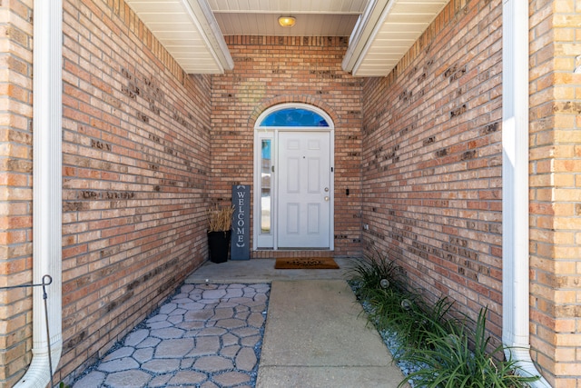 view of exterior entry featuring brick siding