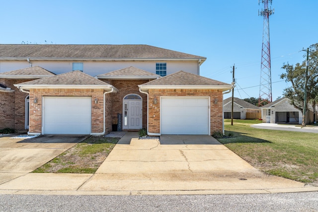 view of front of property featuring an attached garage, a front lawn, roof with shingles, and concrete driveway