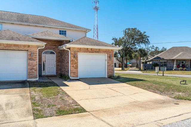 traditional-style home with a front lawn, concrete driveway, an attached garage, a shingled roof, and brick siding