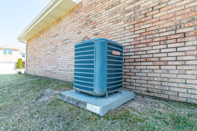 exterior details featuring brick siding and central AC