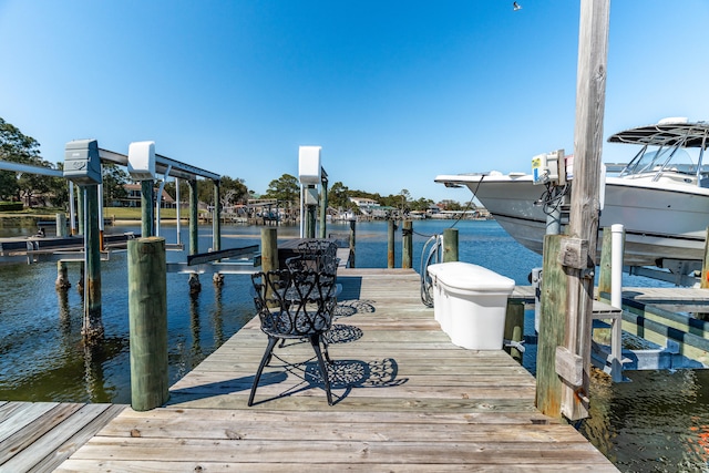 dock area with boat lift and a water view