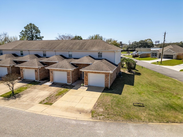 view of front facade featuring roof with shingles, concrete driveway, a front lawn, a garage, and brick siding