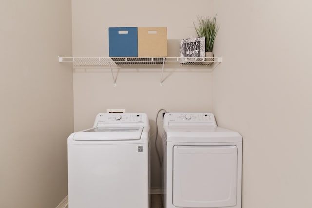 laundry room featuring baseboards, separate washer and dryer, and laundry area