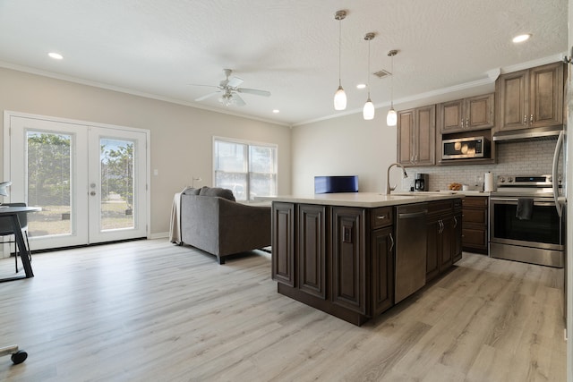 kitchen featuring backsplash, crown molding, stainless steel appliances, and light countertops