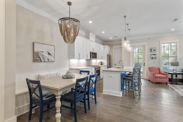 dining area featuring a chandelier, recessed lighting, dark wood-style flooring, visible vents, and crown molding