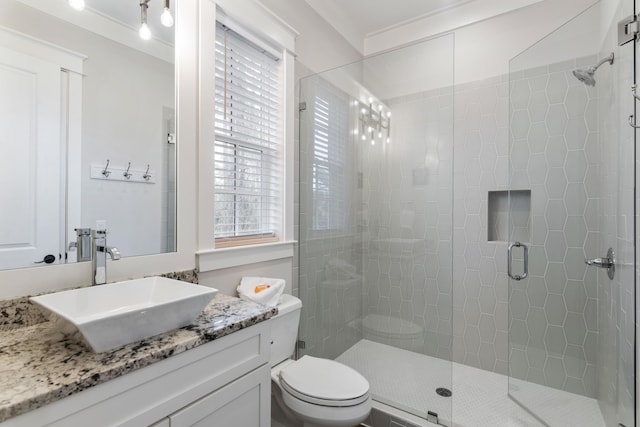 bathroom featuring a stall shower, vanity, and toilet