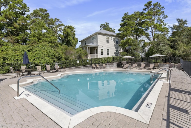 community pool featuring a patio area and fence