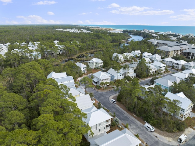 drone / aerial view with a water view, a residential view, and a wooded view