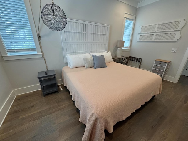 bedroom with wood finished floors and baseboards