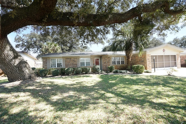 ranch-style home with a garage, brick siding, and a front yard