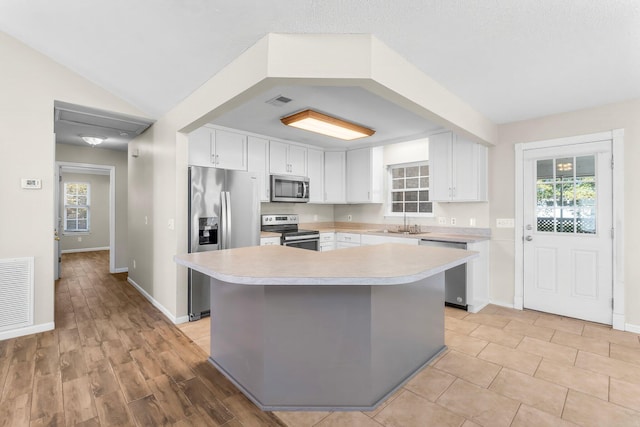 kitchen with white cabinets, visible vents, stainless steel appliances, and light countertops