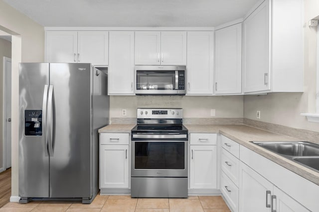 kitchen with light countertops, appliances with stainless steel finishes, and white cabinetry