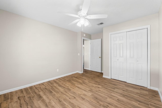 unfurnished bedroom with a ceiling fan, visible vents, baseboards, a closet, and light wood finished floors