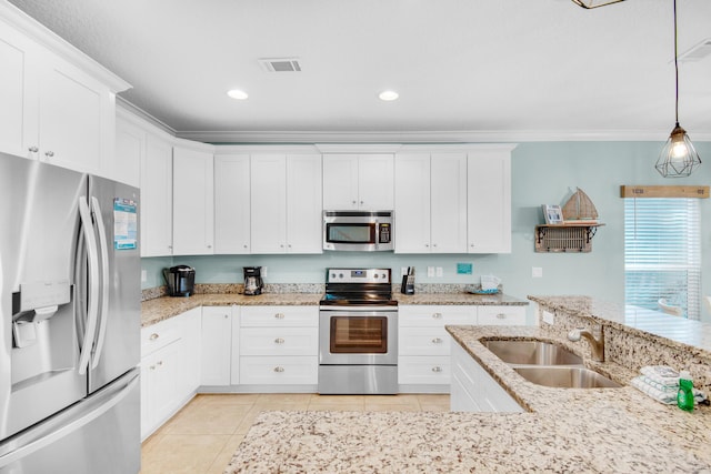 kitchen featuring light tile patterned floors, stainless steel appliances, a sink, white cabinets, and crown molding