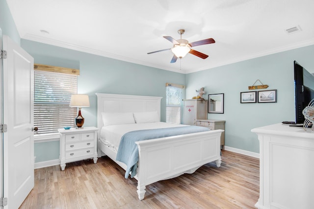 bedroom featuring light wood-style flooring, a ceiling fan, baseboards, visible vents, and crown molding