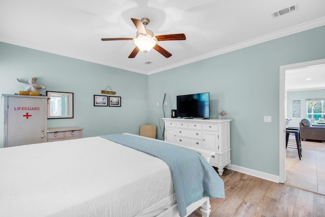 bedroom featuring ceiling fan, visible vents, baseboards, light wood-style floors, and ornamental molding