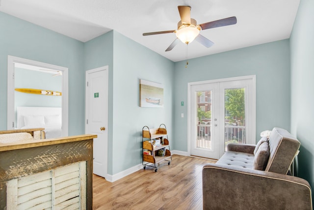 living area with light wood-style floors, ceiling fan, baseboards, and french doors