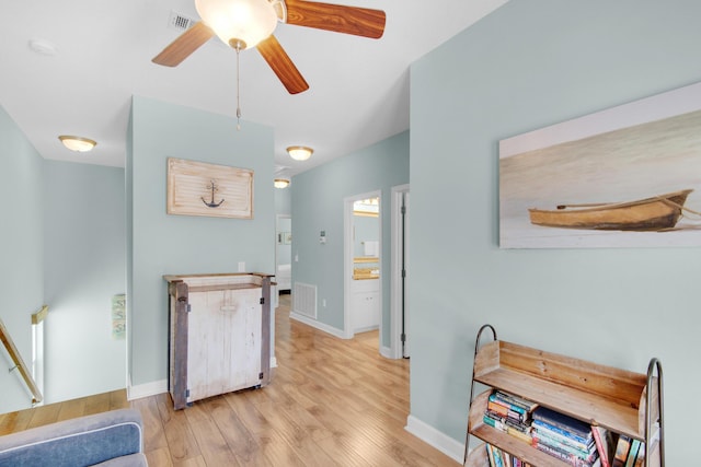 interior space with light wood finished floors, baseboards, visible vents, and a ceiling fan