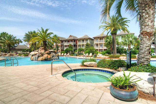 community pool featuring a patio and a hot tub