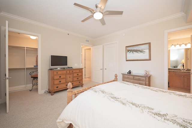 bedroom featuring ornamental molding, a closet, light carpet, and connected bathroom