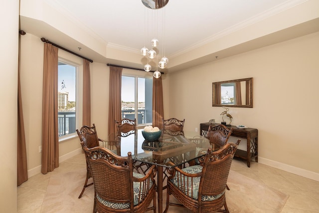 dining room with baseboards, a raised ceiling, crown molding, and light tile patterned flooring