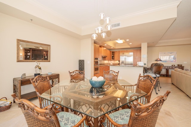 dining area featuring ornamental molding, a tray ceiling, visible vents, and light tile patterned floors