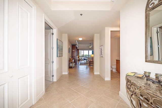 hall with light tile patterned floors and baseboards