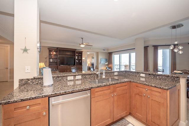 kitchen with a sink, stainless steel dishwasher, dark stone counters, decorative light fixtures, and crown molding