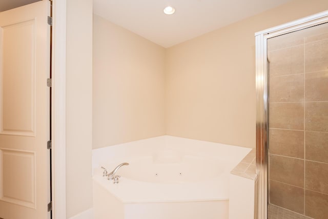 full bathroom with a tub with jets, a shower stall, and recessed lighting