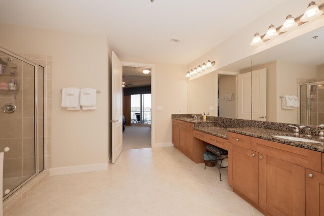 bathroom with baseboards, double vanity, a sink, and a shower stall