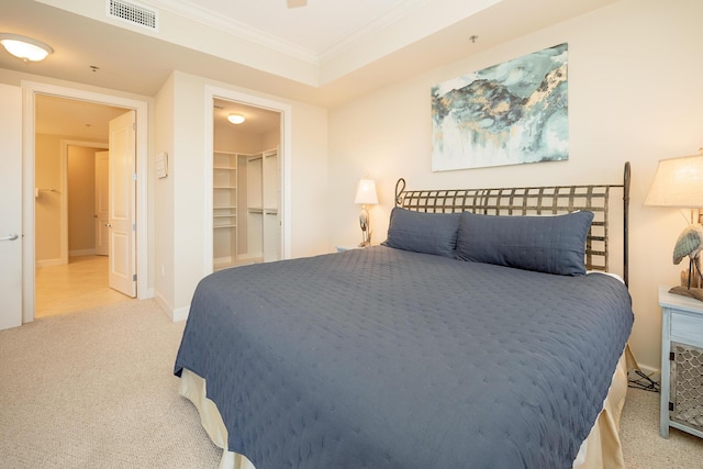 carpeted bedroom with baseboards, a spacious closet, visible vents, and ornamental molding