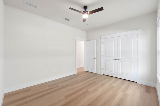 unfurnished bedroom with light wood finished floors, a closet, visible vents, ceiling fan, and baseboards