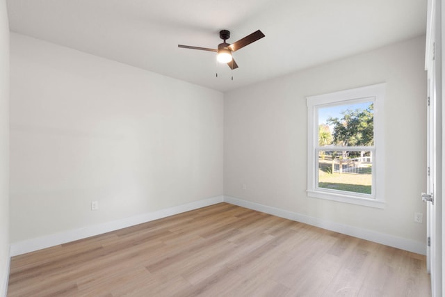 empty room featuring baseboards, a ceiling fan, and light wood-style floors