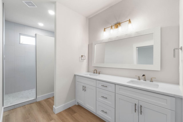 full bathroom with visible vents, walk in shower, a sink, and wood finished floors