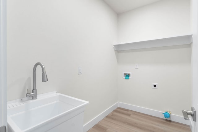 laundry room featuring laundry area, light wood finished floors, a sink, hookup for a washing machine, and electric dryer hookup