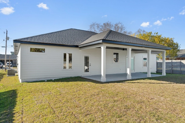 back of property featuring a patio area, roof with shingles, cooling unit, and a yard