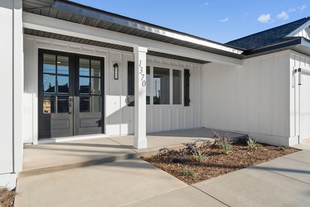 entrance to property with french doors, a porch, and a shingled roof