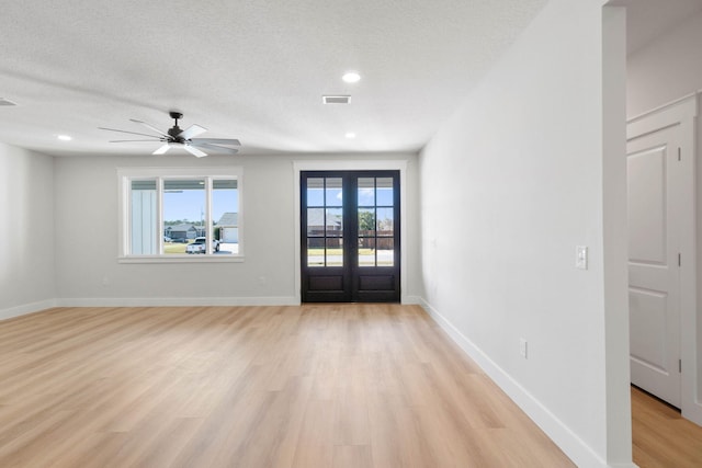 entrance foyer with visible vents, baseboards, a textured ceiling, french doors, and light wood-type flooring