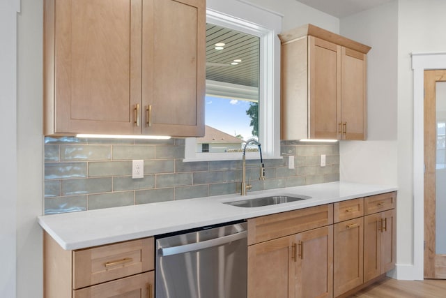 kitchen featuring decorative backsplash, dishwasher, light countertops, light brown cabinetry, and a sink