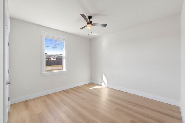 empty room with ceiling fan, light wood-type flooring, and baseboards