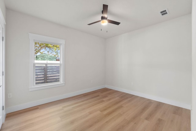 spare room with ceiling fan, light wood-style flooring, visible vents, and baseboards